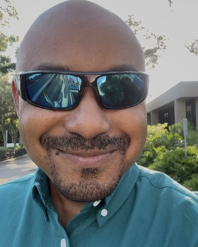Still from a reel: Martial outdoors in sunglasses and a teal shirt